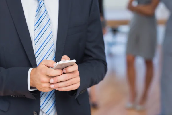 Affärsman textilen med kollegor bakom honom — Stockfoto