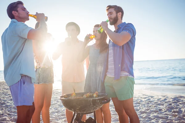 Amigos felizes fazendo churrasco e bebendo cerveja — Fotografia de Stock