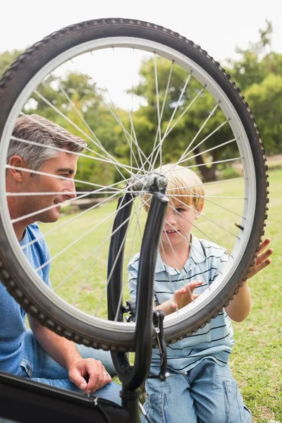 Pai e seu filho consertando uma bicicleta — Fotografia de Stock