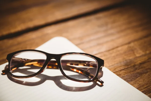 Empty notepad with reading glasses — Stock Photo, Image