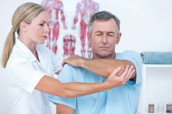 Doctor estirando un brazo de hombre —  Fotos de Stock