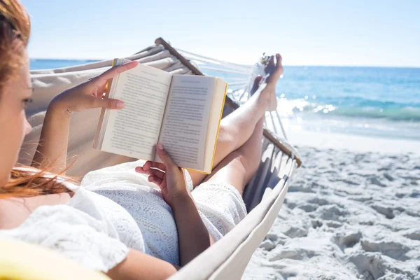 Brünette liest ein Buch, während sie sich in der Hängematte entspannen — Stockfoto