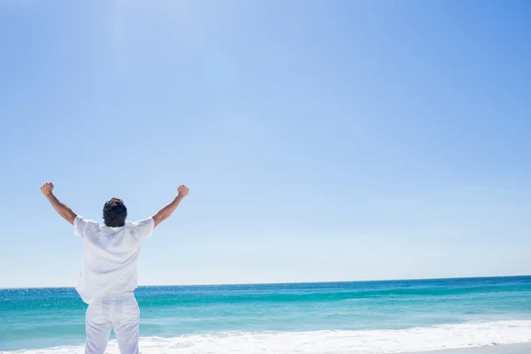 Man stretching his arms in front of the sea — Stock Photo, Image