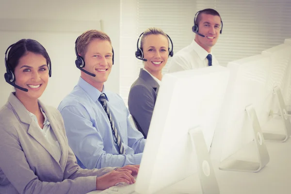 Geschäftsteam arbeitet am Computer und trägt Headsets — Stockfoto