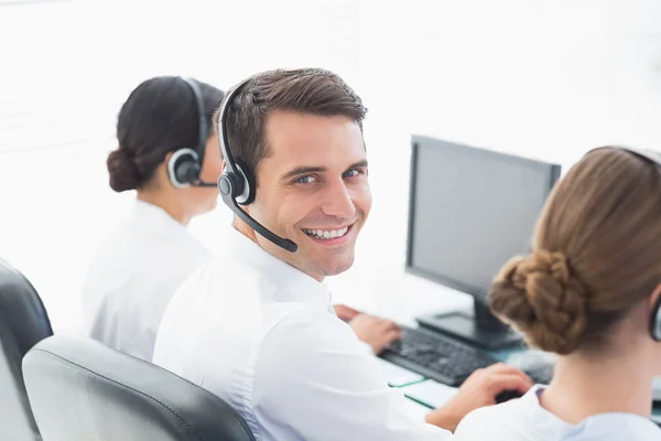 Pessoas de negócios com fones de ouvido usando computadores — Fotografia de Stock