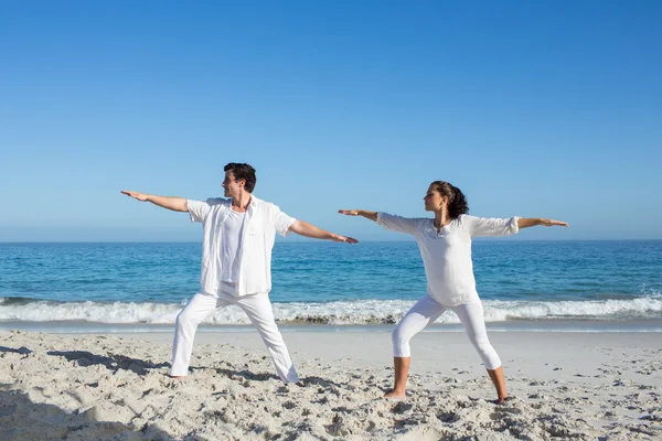 Happy couple doing yoga beside the water — Stock Photo, Image