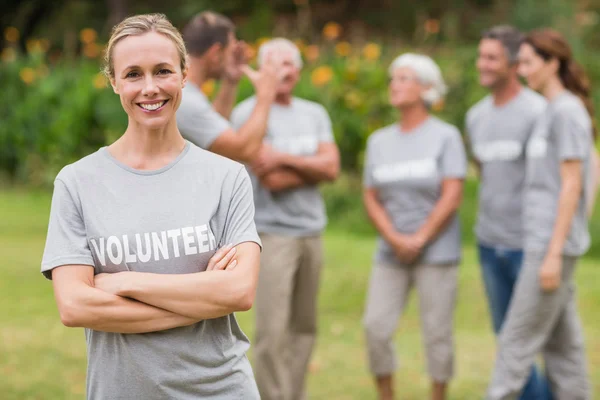 Happy volunteer looking at camera with arms crossed — Stock Photo, Image