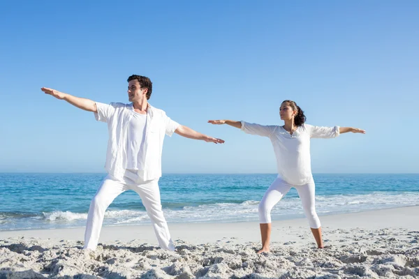 Gelukkige paar doen yoga naast het water — Stockfoto