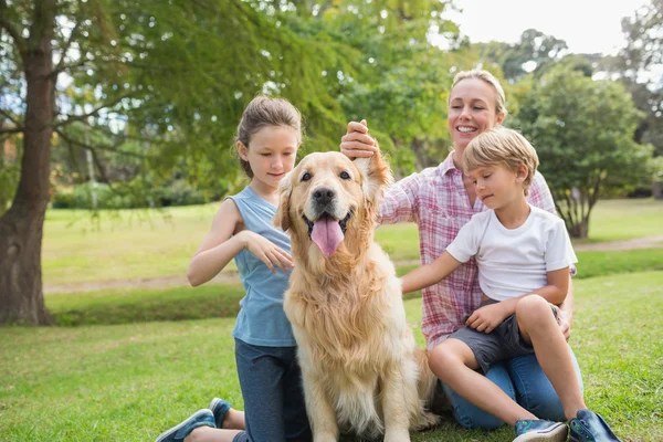 Familia feliz jugando con su perro — Foto de Stock