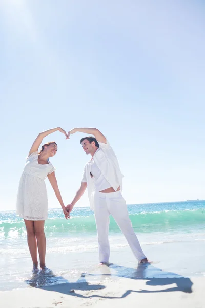 Happy couple forming heart shape with their hands — Stock Photo, Image