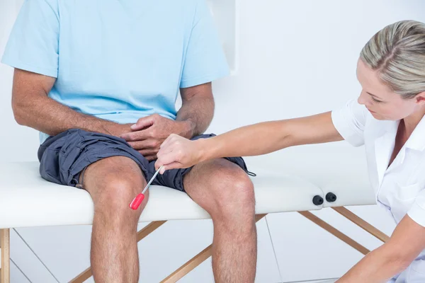 Doctor checking reflexes of the knee of her patient — Stock Image Doctor checking reflexes of the knee of her patient Stock Picture