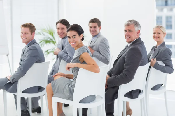 Smiling business team looking at camera during conference — Stock Photo, Image