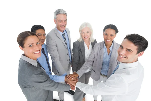 Executives holding hands together in office Stock Image