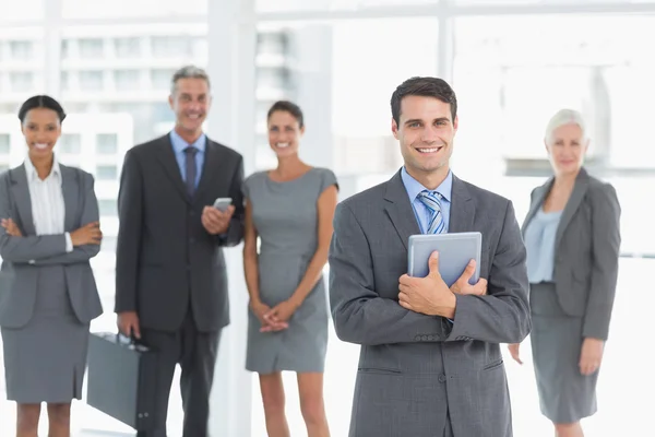 Empresario usando tableta digital con colegas detrás — Foto de Stock