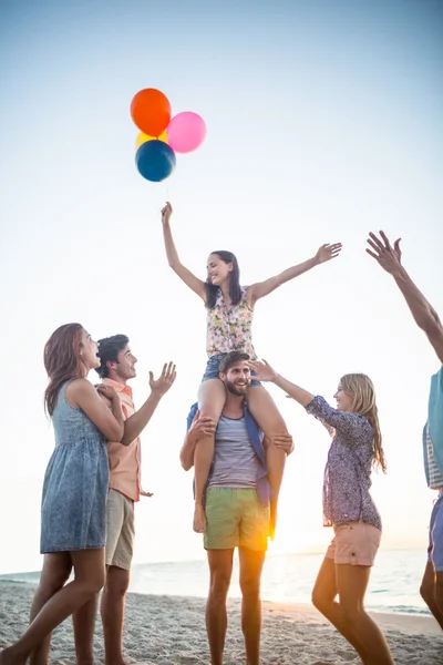 Amici felici che ballano sulla sabbia con palloncino — Foto Stock