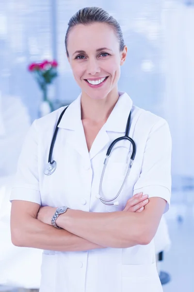 Feliz médico sonriendo a la cámara detrás de la cama —  Fotos de Stock