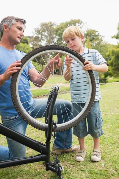 Padre e suo figlio che riparano una bici — Foto Stock