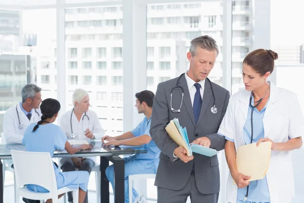 Mannelijke en vrouwelijke artsen met rapporten — Stockfoto