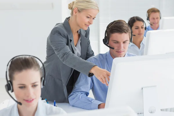 Manager hilft Callcenter-Mitarbeiterin — Stockfoto