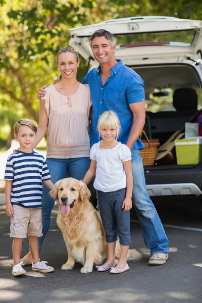 Счастливая семья с собакой в парке — стоковое фото