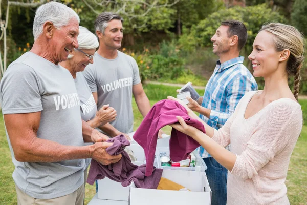 Lycklig volontär familj separera donationer tyger — Stockfoto