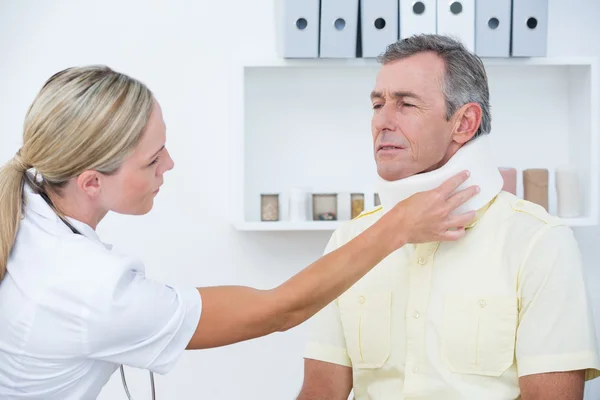 Medico esaminando paziente che indossa il collare — Foto Stock