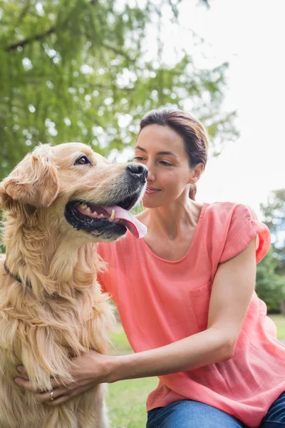 Mooie brunette met haar hond in het park — Stockfoto