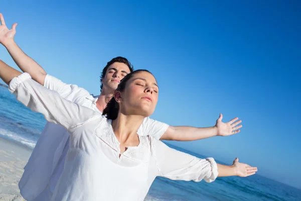 Glückliches Paar beim Yoga neben dem Wasser — Stockfoto