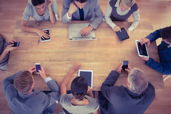 Zakelijke team dat werkt op hun multimedia-apparaten — Stockfoto