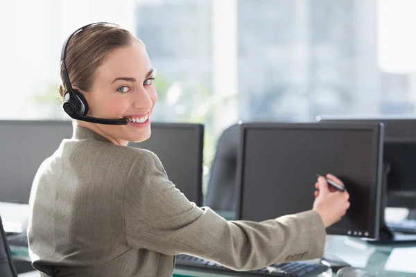 Donna d'affari sorridente che tocca lo schermo del computer con la penna — Foto Stock