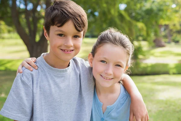 Lachende broer of zus kijken camera in het park — Stockfoto