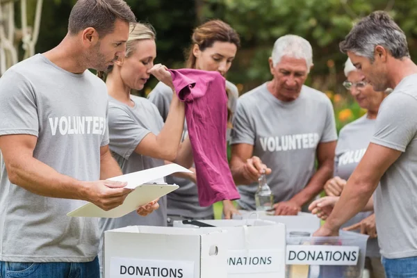 Feliz voluntario mirando la caja de donaciones — Foto de Stock