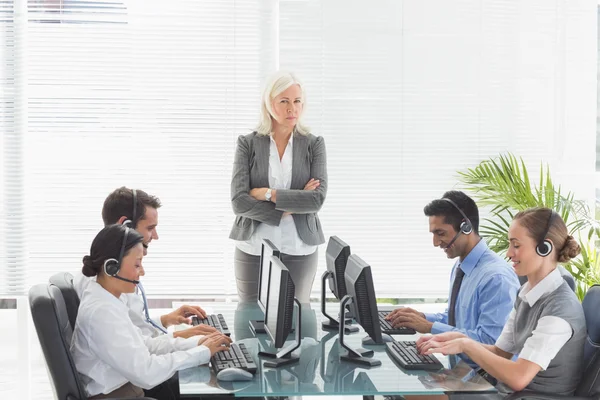 Unhappy businesswoman monitoring her colleagues — Stock Photo, Image