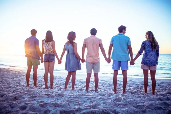 Happy vrienden hand in hand terug naar camera — Stockfoto