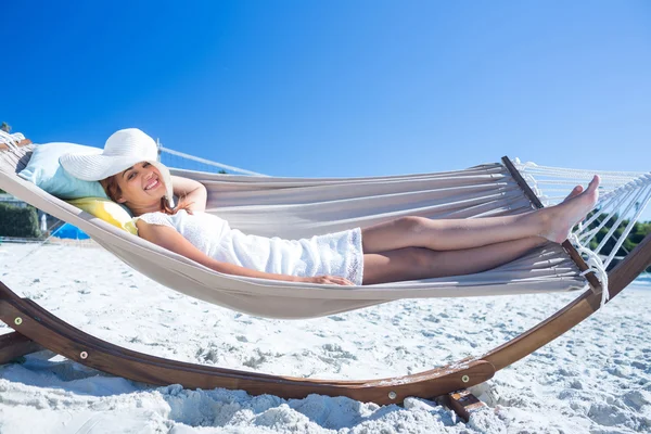 Pretty brunette relaxing with her straw hat in the hammock — Stock Photo, Image