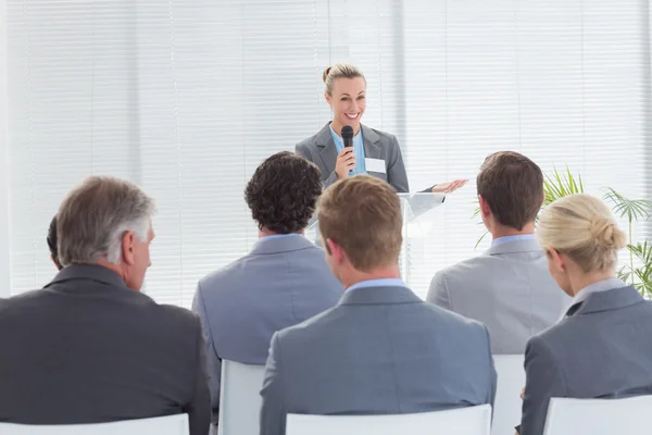 Jolie femme d'affaires parlant au micro pendant la conférence — Photo