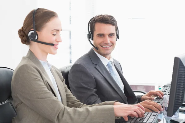 Geschäftsleute mit Headsets, die Computer benutzen — Stockfoto