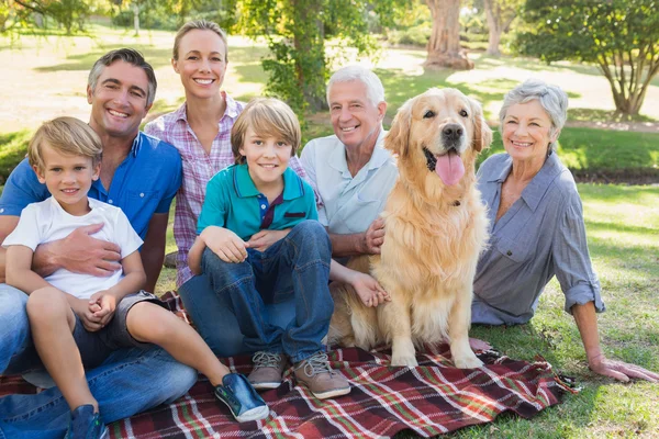 Gelukkige familie glimlachen op de camera met hun hond — Stockfoto