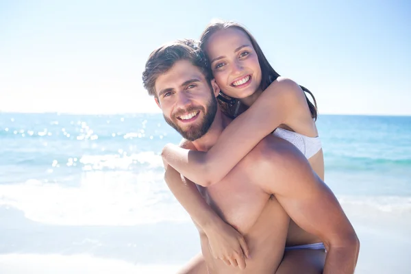 Bonito homem dando porquinho de volta para sua namorada — Fotografia de Stock