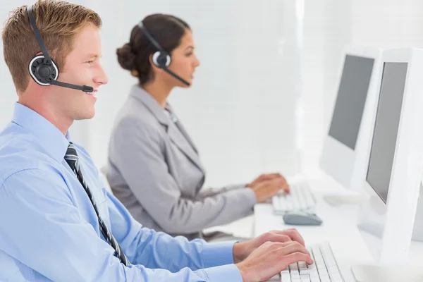 Verksamhet team arbetar med datorer och bär headset — Stockfoto