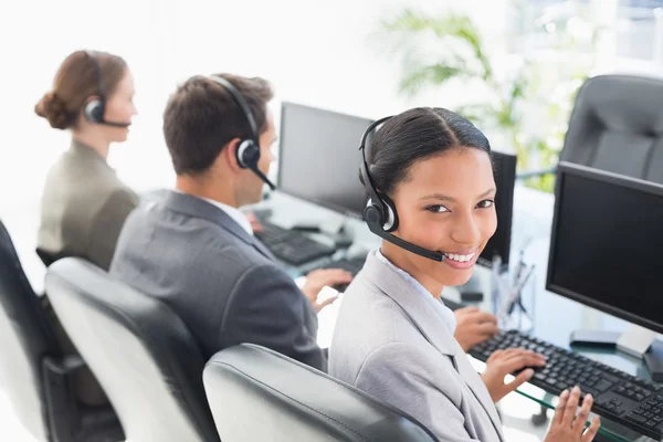 Mensen uit het bedrijfsleven met headsets met behulp van computers — Stockfoto