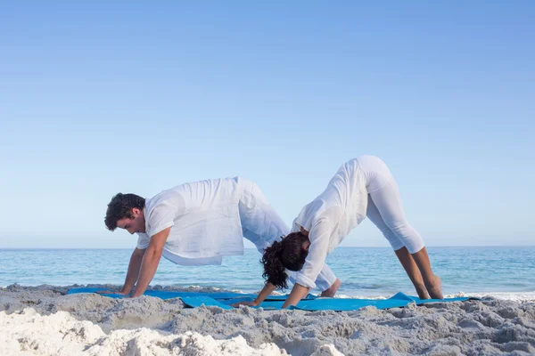 Mutlu çift su yanında yoga yaparken — Stok fotoğraf