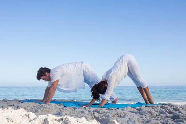 Pareja feliz haciendo yoga al lado del agua —  Fotos de Stock