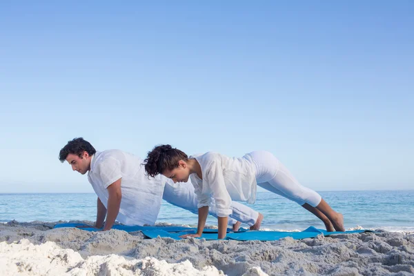 Mutlu çift su yanında yoga yaparken — Stok fotoğraf