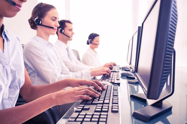 Business people with headsets using computers — Stock Photo, Image