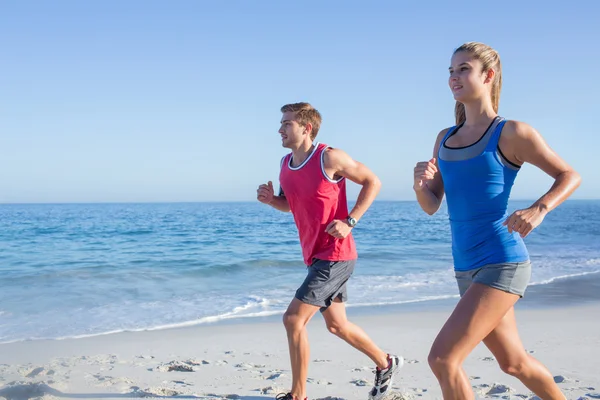 Happy couple running together beside the water — Stock Photo, Image