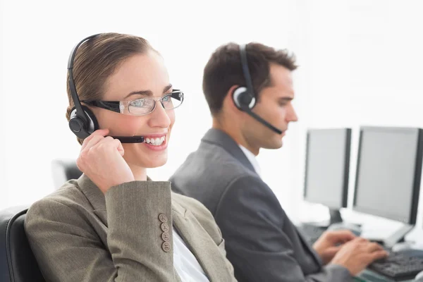 Geschäftsleute mit Headsets, die Computer benutzen — Stockfoto