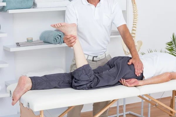 Physiothérapeute faisant massage des jambes à son patient — Photo