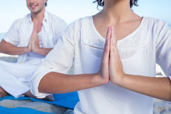 Pareja feliz haciendo yoga al lado del agua — Foto de Stock