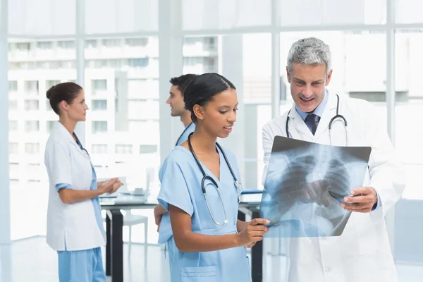 Male and female doctors examining x-ray — Stock Photo, Image